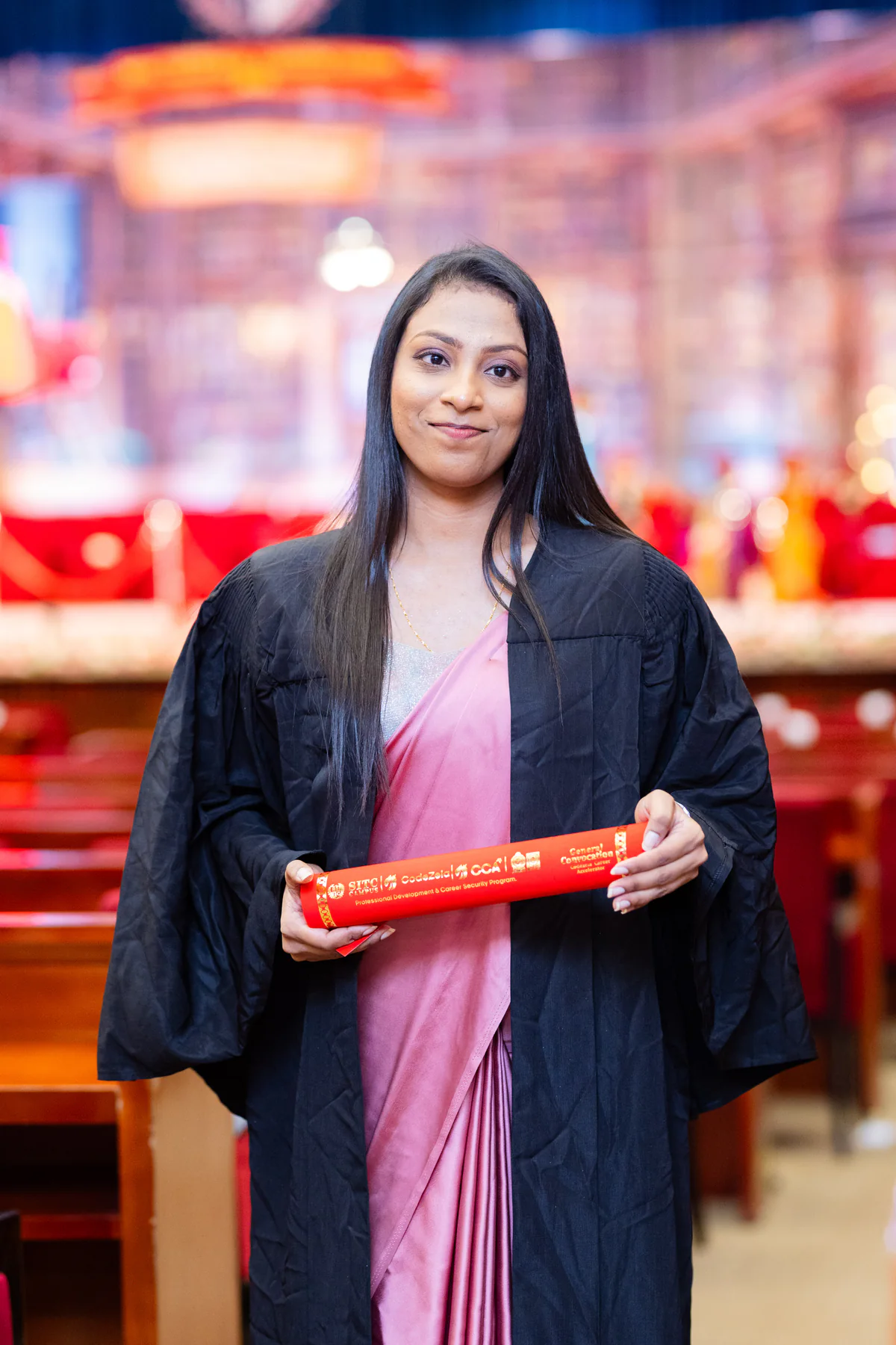 A graduate photographed against the convocation stage
