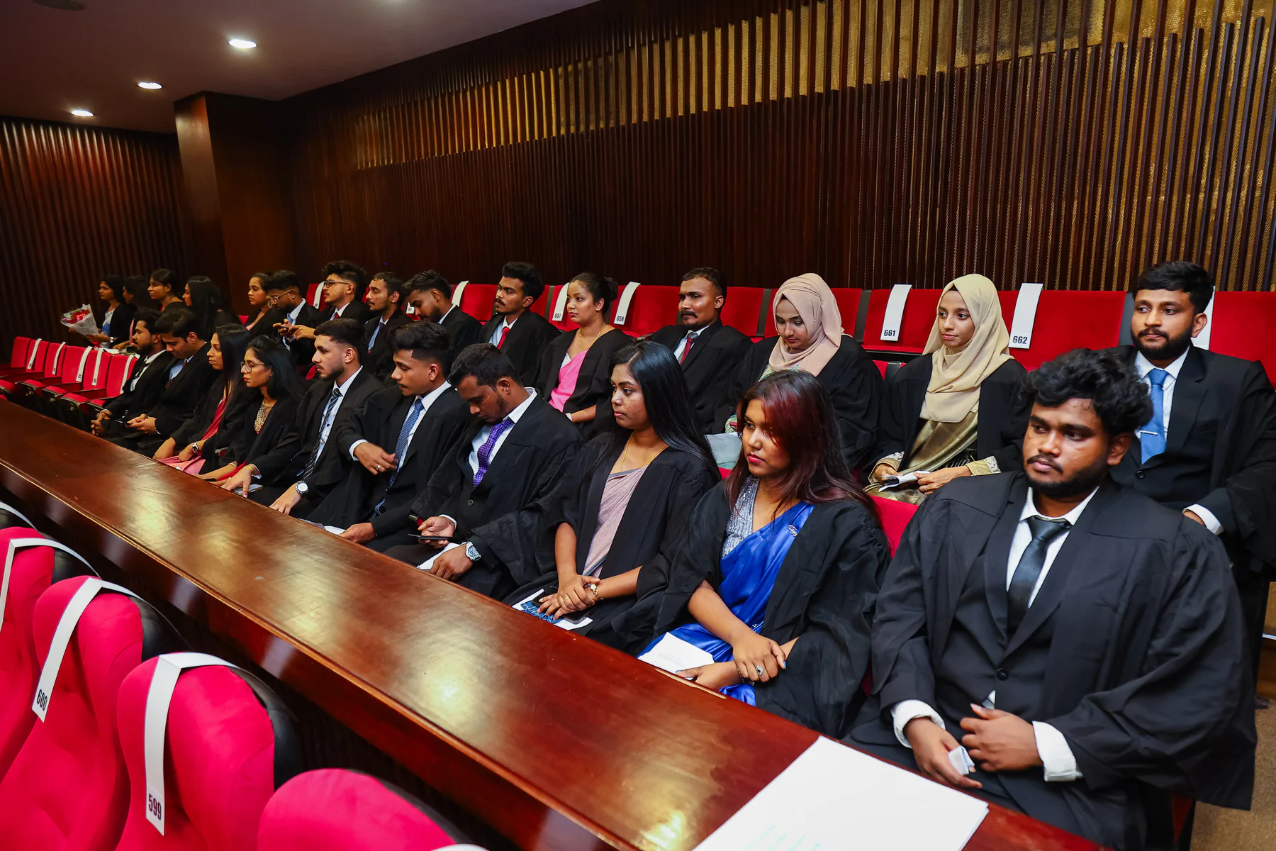 Graduates seated together inside the convocation auditorium