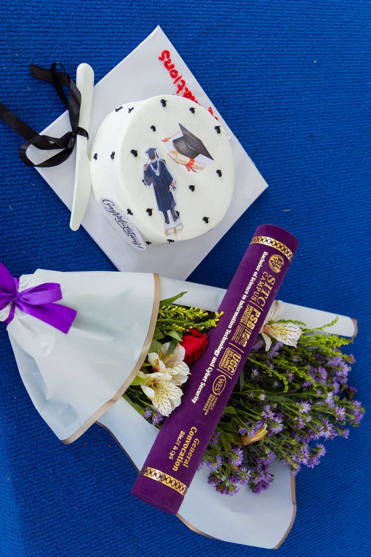 Graduation scrolls and a celebration cake prepared for a graduate